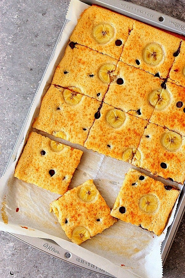 Sheet Pan Pancakes Recipe - the fastest way to make pancakes! Topped with bananas and chocolate and baked to fluffy squares, these pancakes are a must for a weekend breakfast! Sheet Pan Pancakes on baking sheet.