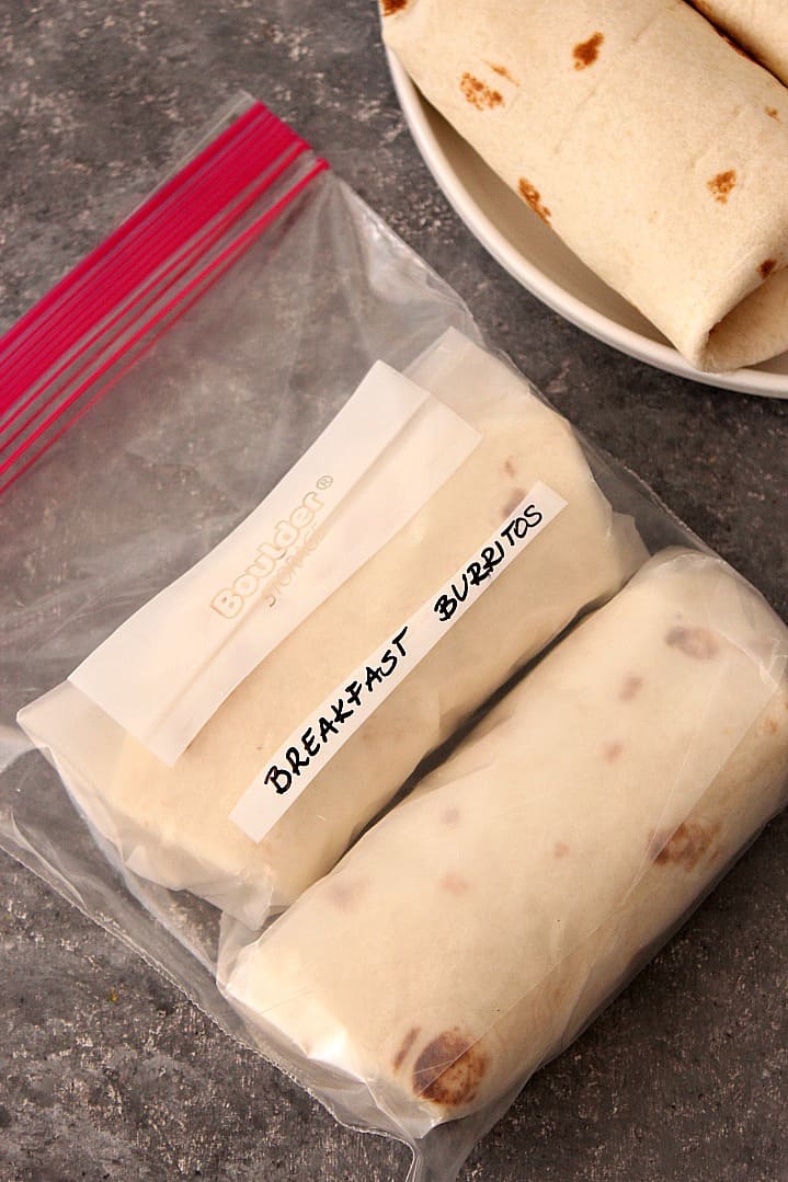 Overhead shot of breakfast burritos in ziploc freezer bag.