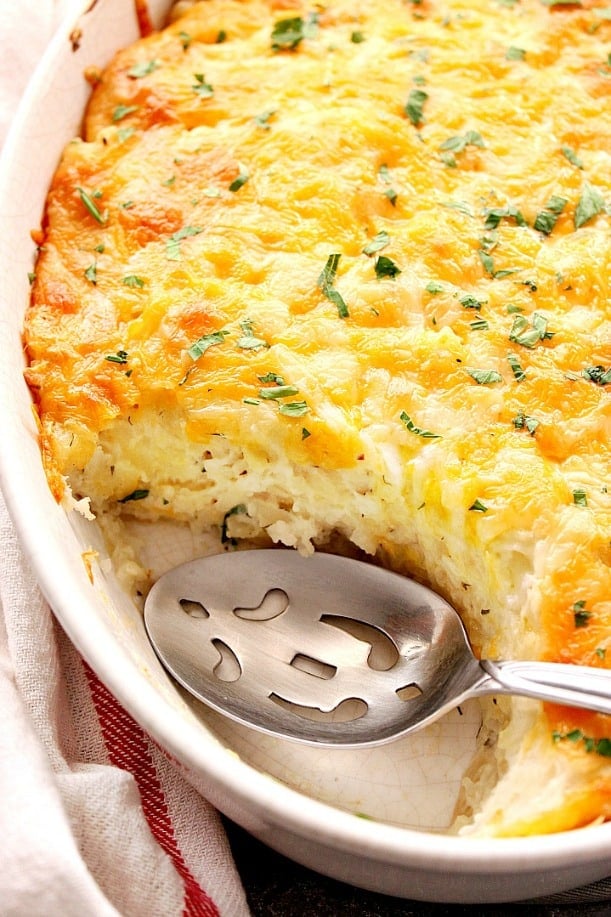 Close up shot of hashbrown casserole in baking dish with spoon.