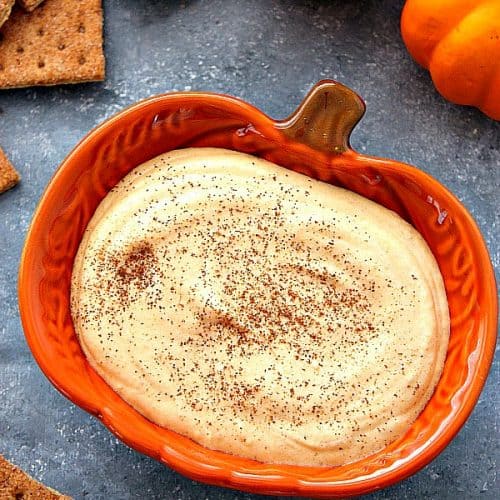 Pumpkin cheesecake dip in orange pumpkin bowl.