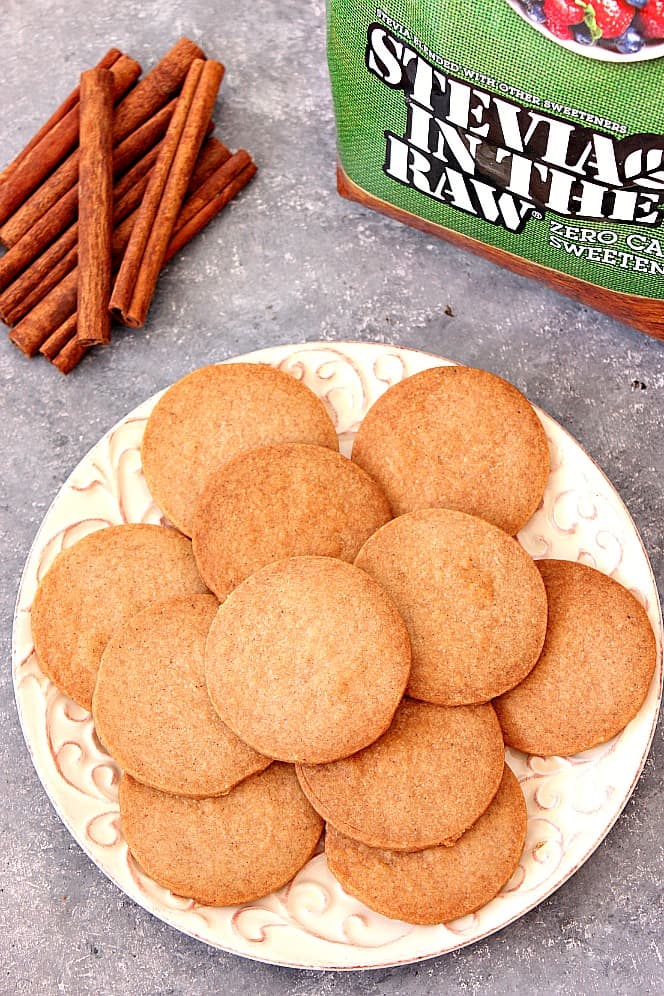 Shortbread cookies on a plate with cinnamon sticks next to it.