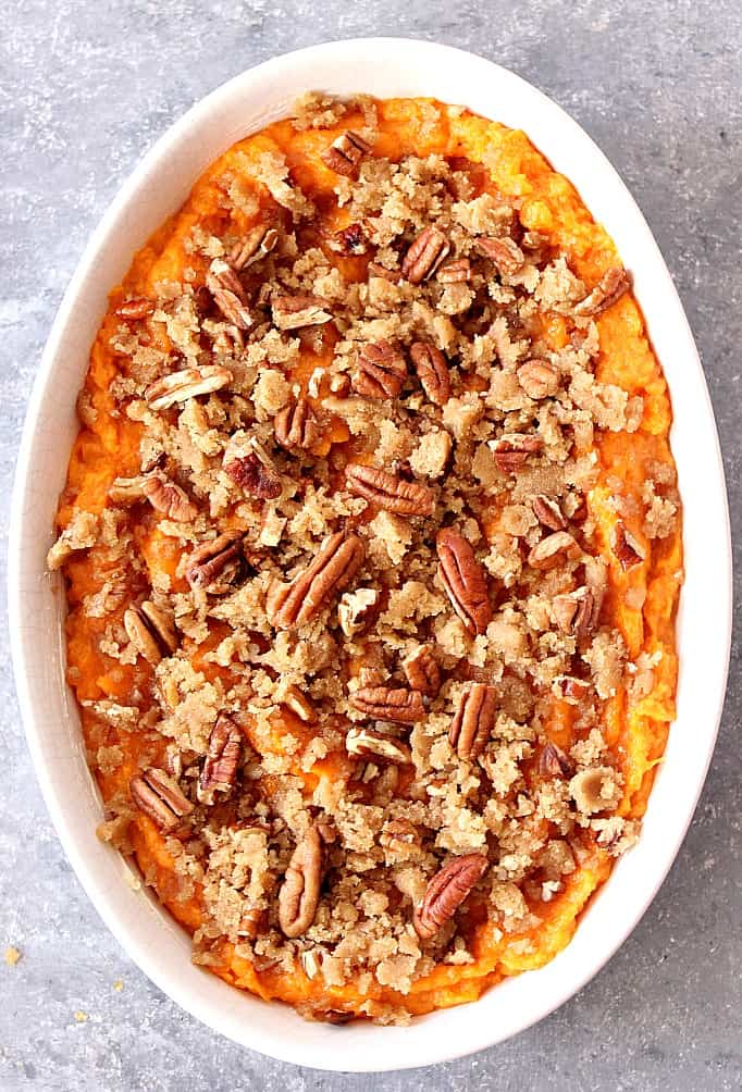 Overhead shot of sweet potato casserole with pecan topping in white baking dish.