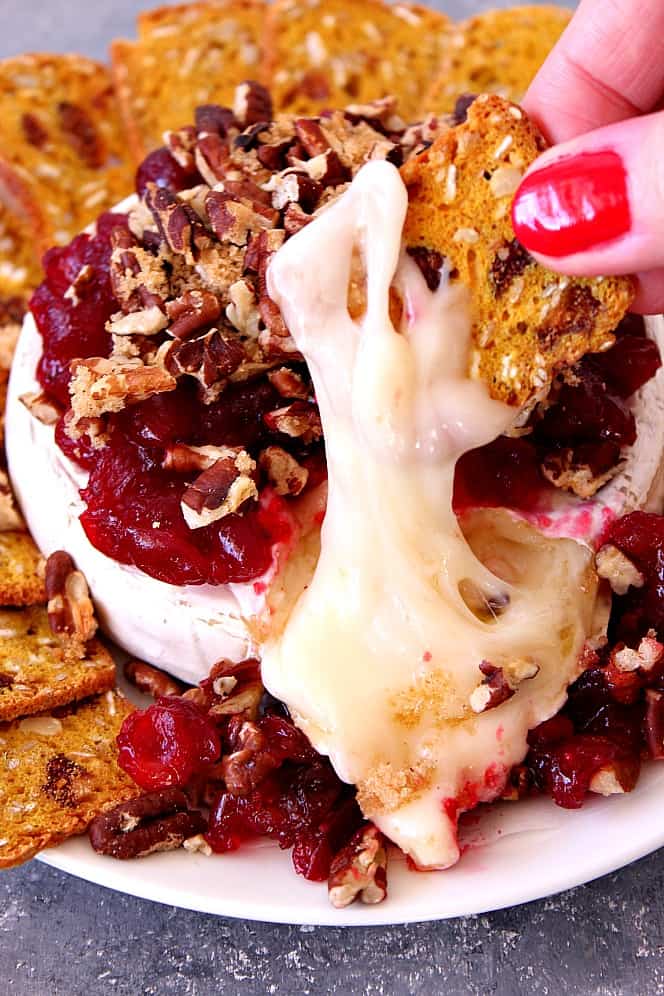 Cranberry Pecan Baked Brie Recipe - creamy gooey cheese topped with tarty cranberries and sweet pecans. Perfect party appetizer for the holiday season! 