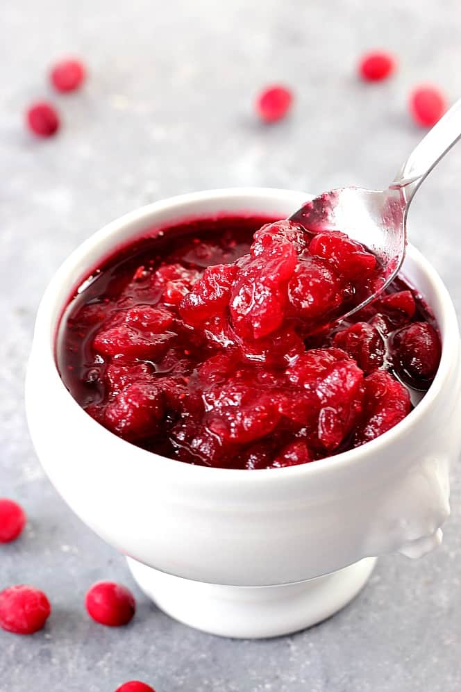 Easy Homemade Cranberry Sauce Recipe - a classic Thanksgiving side dish made from scratch with just 4 ingredients! Perfectly sweet and tarty! Homemade Cranberry Sauce in a white elegant serving dish.