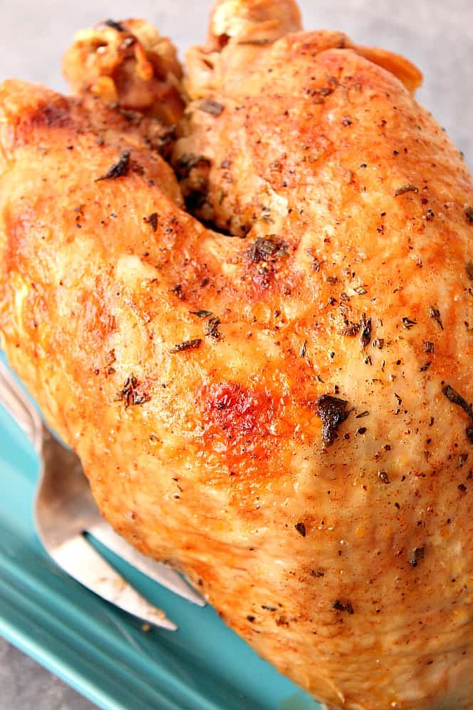 Close up shot of cooked turkey breast on blue serving platter.