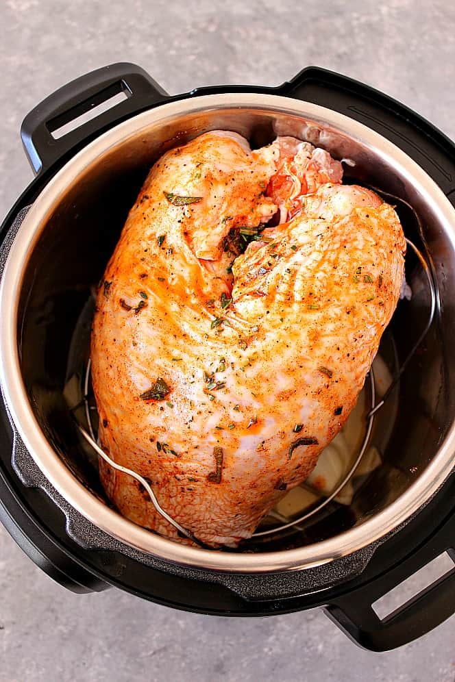 Overhead shot of raw turkey breast, rubbed with spices, in the Instant Pot. 