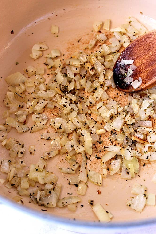 Sauteed onion with Italian seasoning in cast iron Dutch oven.