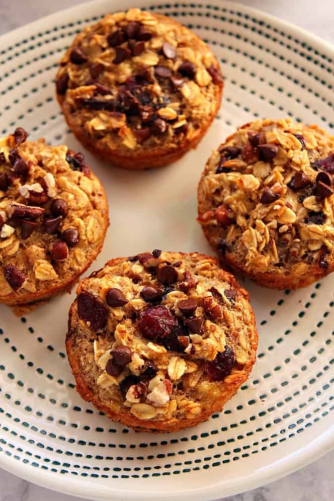 Overhead shot of baked oatmeal muffins on white plate with blue design. 