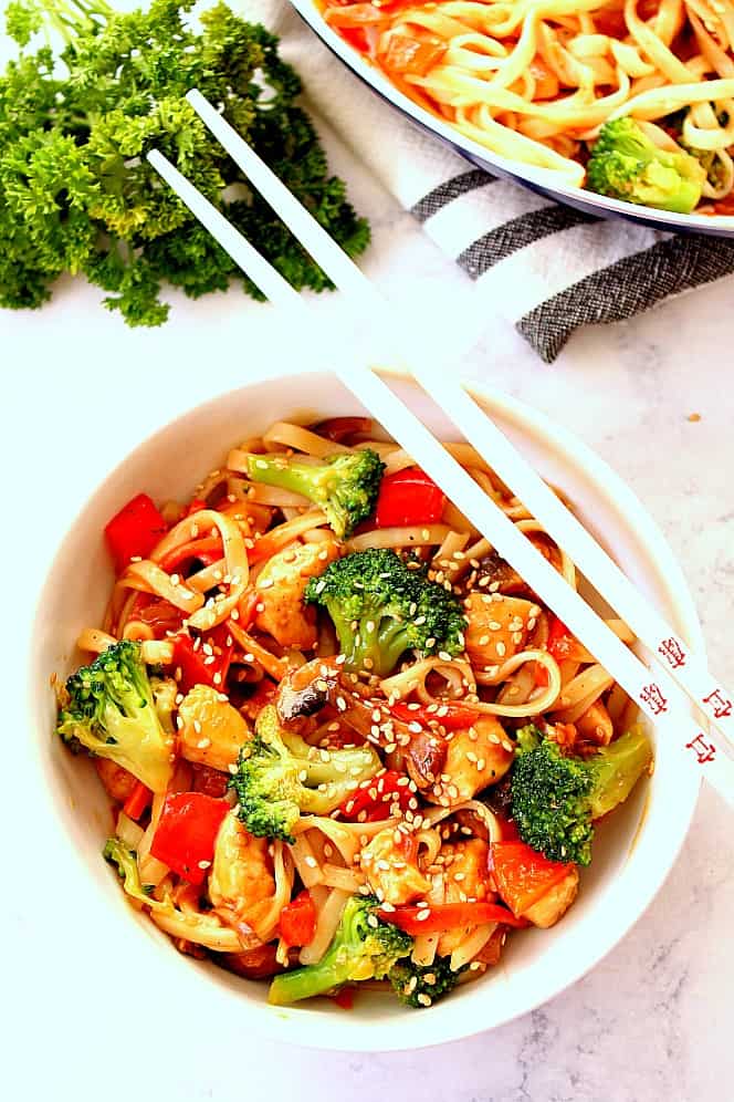 chicken stir fry in bowl with chopsticks