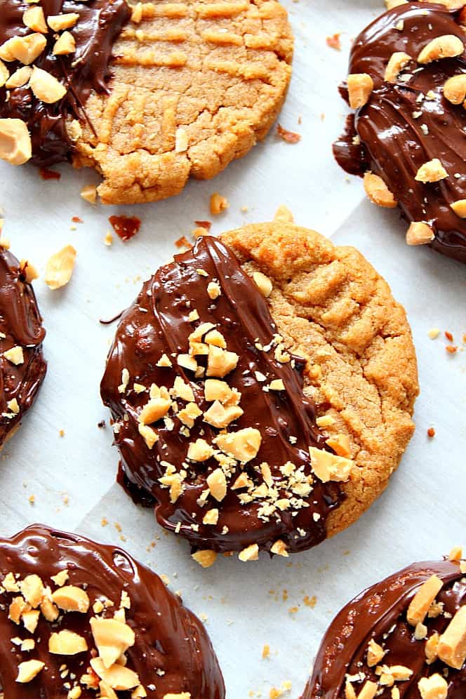 Peanut butter cookies with chocolate and peanuts on a baking sheet.
