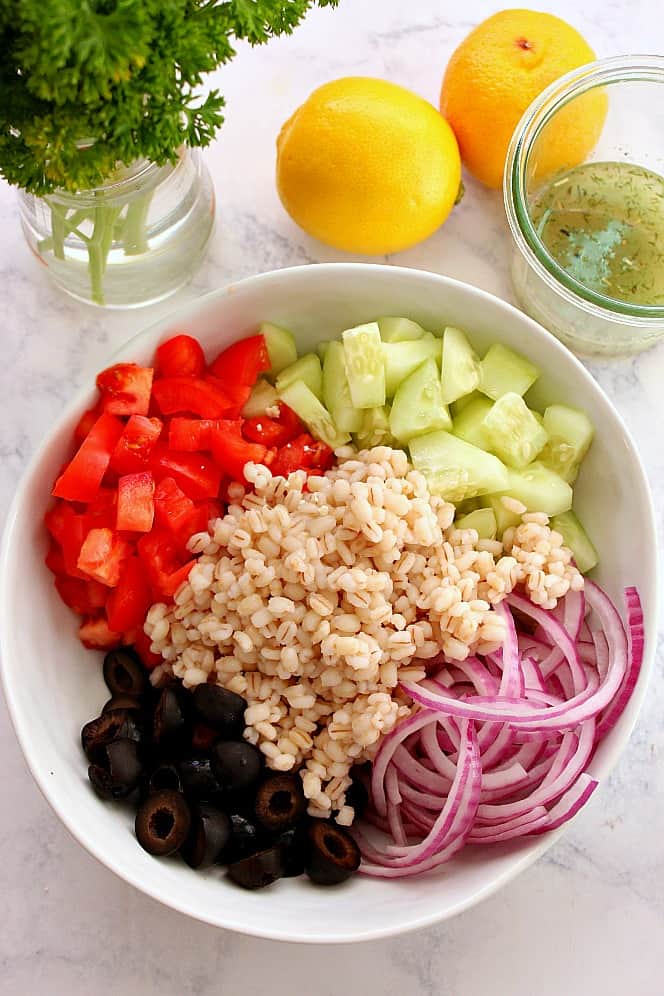 barley cucumber red onion tomatoes and olives in bowl