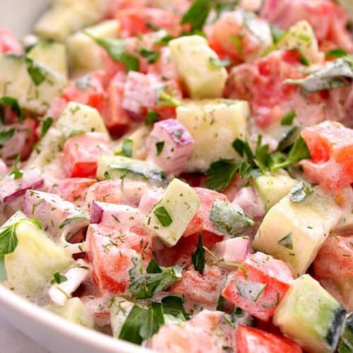 Cucumber salad in a white bowl.