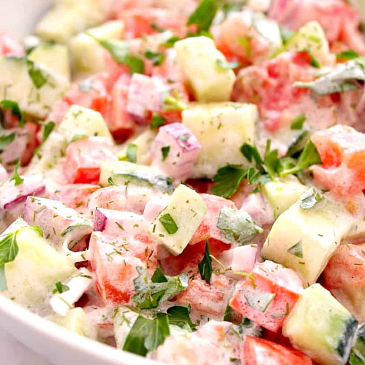 Cucumber salad with tomato in a bowl.