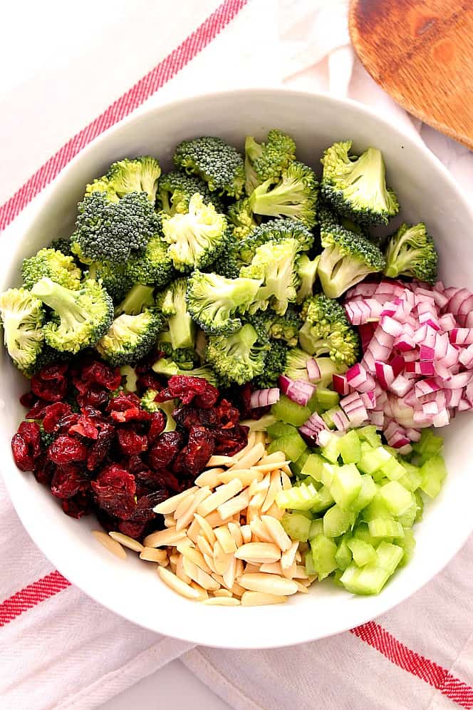 broccoli, dried cranberries, almond, celery and red onion in a bowl