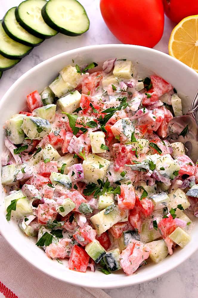 Creamy Cucumber Tomato Salad Recipe - crunchy cucumber, juicy tomatoes and crisp red onions with lighter homemade Ranch dressing make this delicious and flavorful salad a favorite! cucumber tomato salad in a bowl