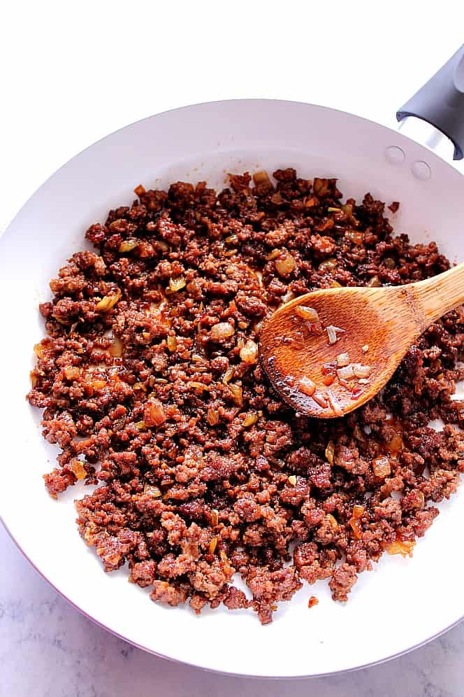 Ground beef cooked in Korean sauce in white pan.