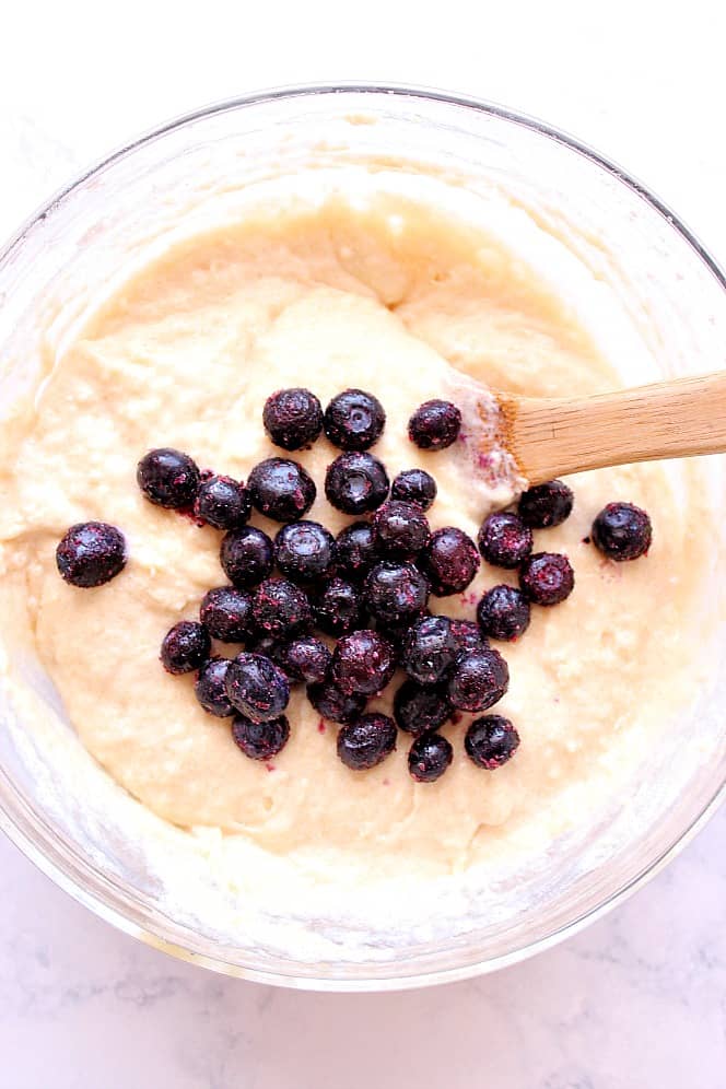 muffin batter in bowl with frozen blueberries