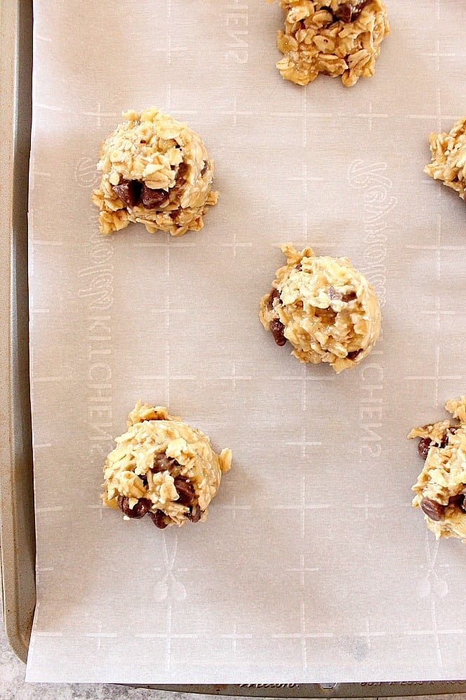 scooped oatmeal cookies on parchment paper lined baking sheet