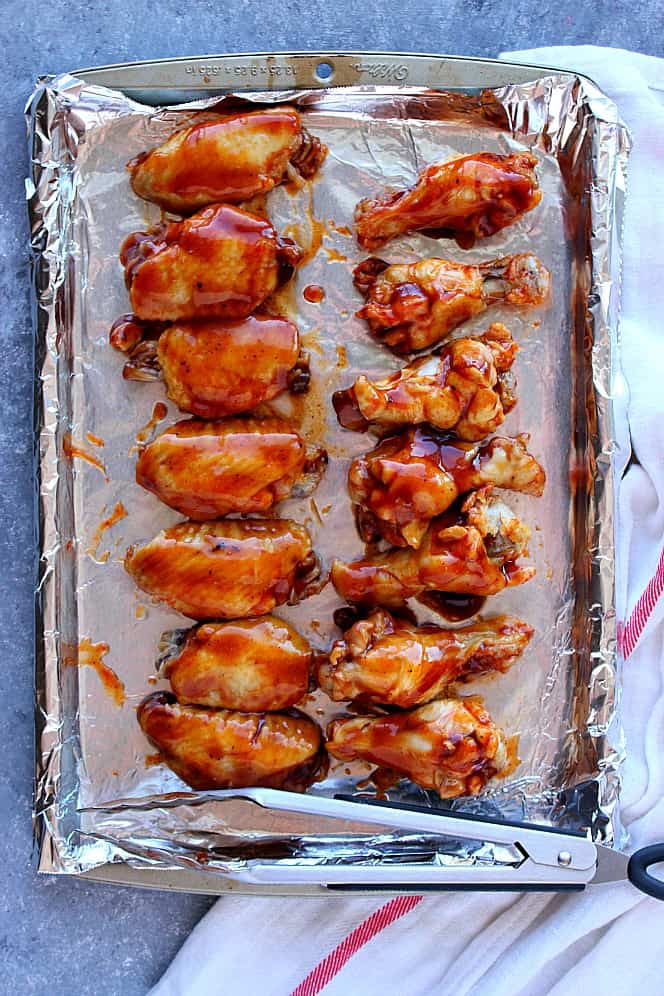 chicken wings coated in bbq sauce on baking sheet