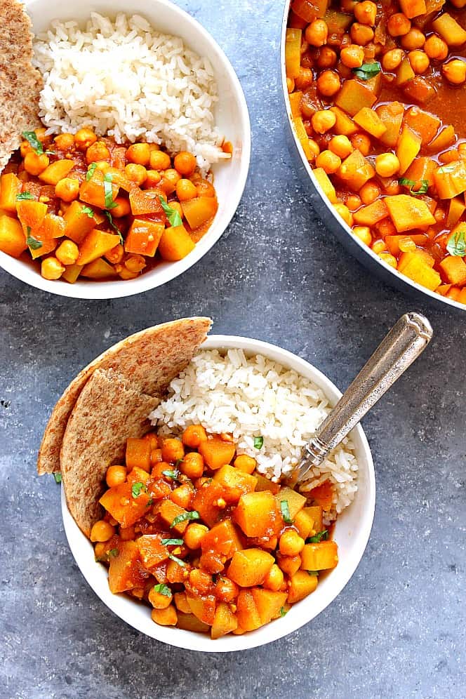 Easy Chickpea and Potato Curry Recipe - spicy and saucy chana aloo curry with chickpeas and potatoes that cooks under 20 minutes. Healthy vegetarian meal served with rice and flatbread. chickpea and potato curry in bowls