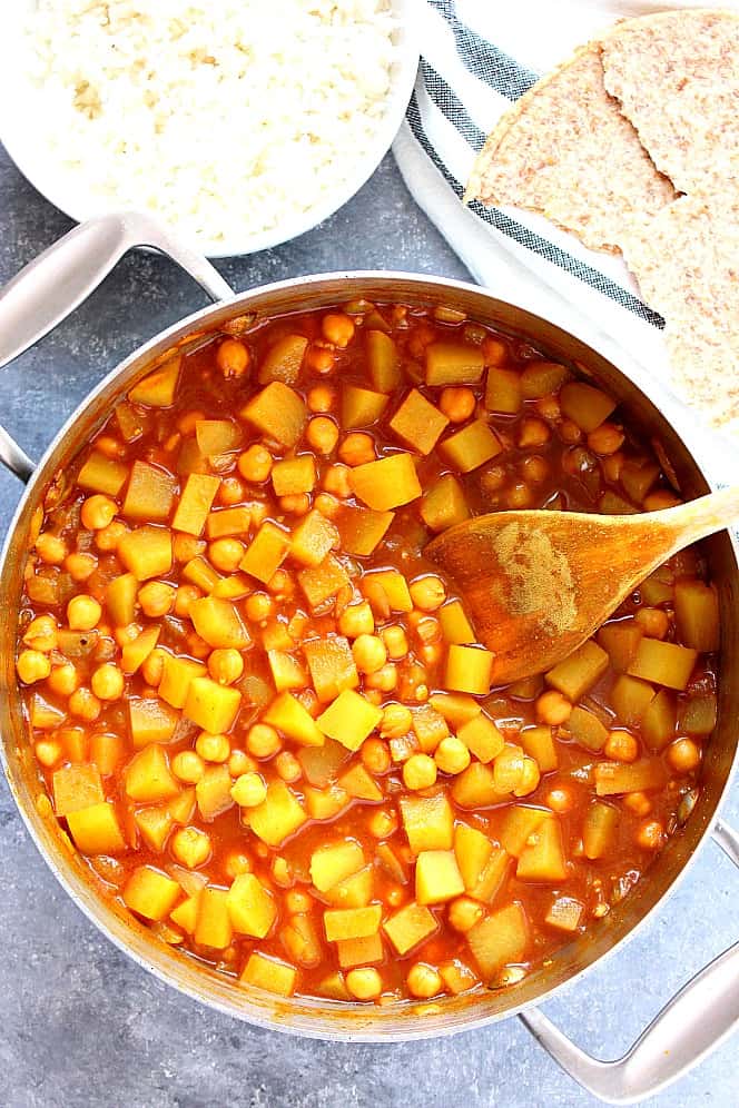 curry with potatoes and chickpeas in a stainless steel pan