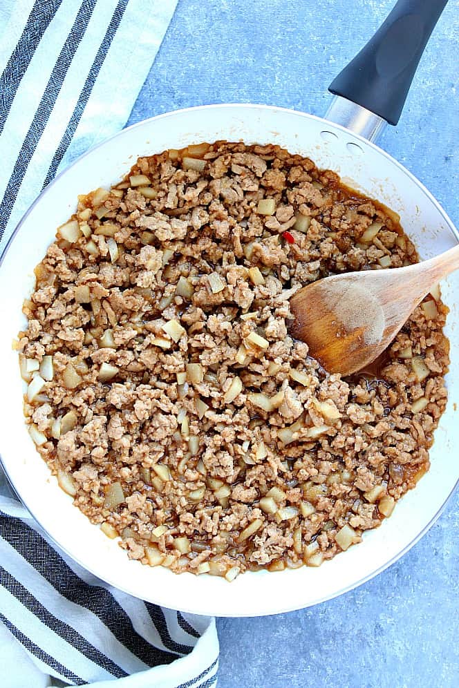 Ground chicken cooked in Asian sauce, in white pan. 