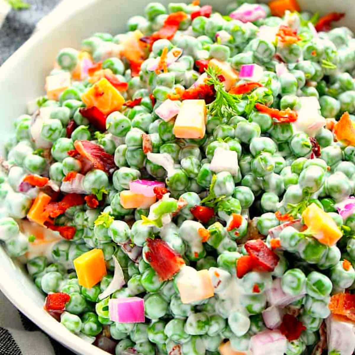 Pea salad in a white bowl.