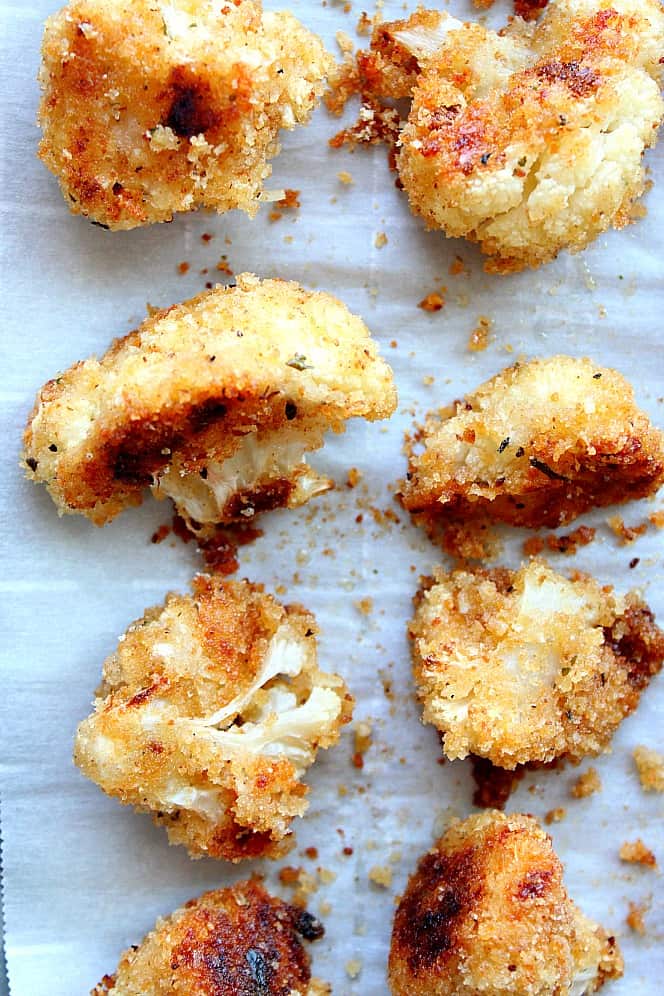 Roasted Garlic Parmesan Cauliflower Recipe - crispy cauliflower bites with garlic Parmesan breading, baked in the oven instead of fried. So tasty! Overhead shot of golden crispy cauliflower bites.