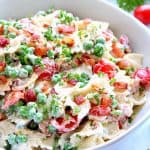 Pasta salad with bacon in a white bowl.