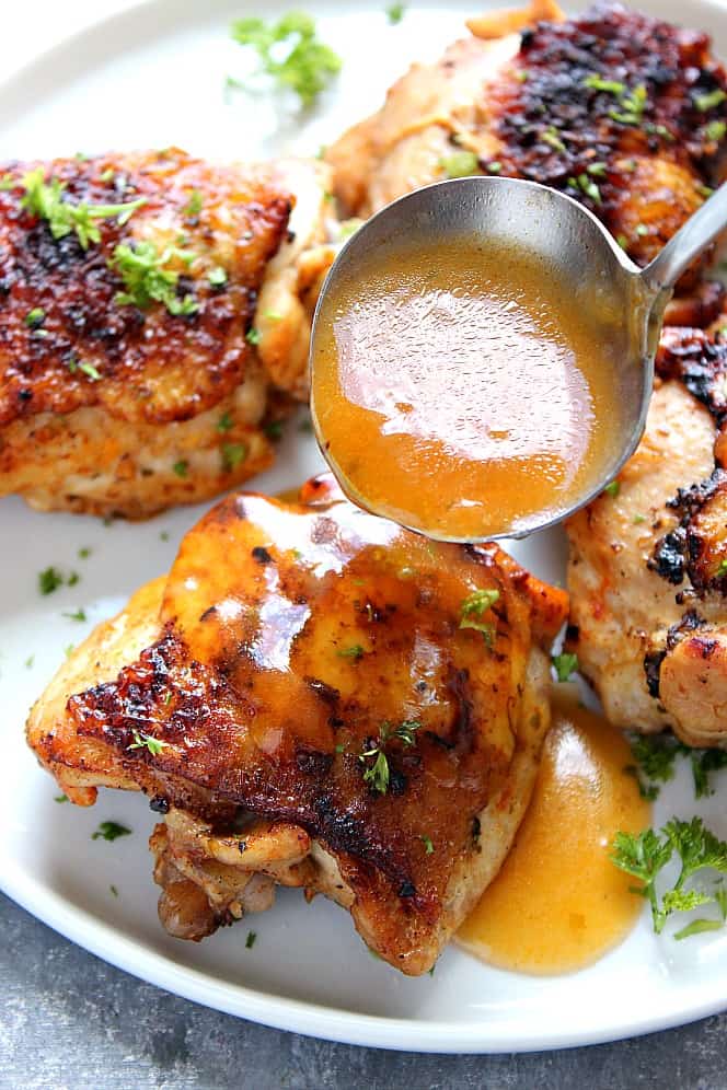 Close up shot of gravy being poured over chicken thigh cooked in pressure cooker. 