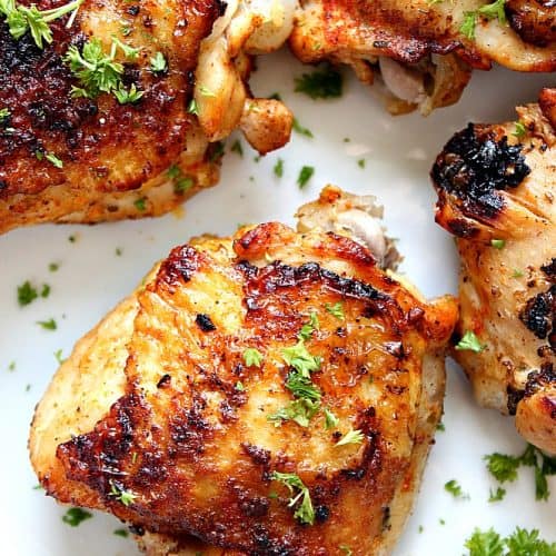 Instant Pot Chicken Thighs with crispy skin, on white plate.