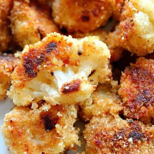 Square image of breaded roasted cauliflower florets on a plate.