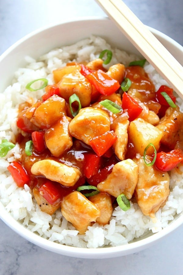 Sweet and Sour Chicken with rice in white bowl.