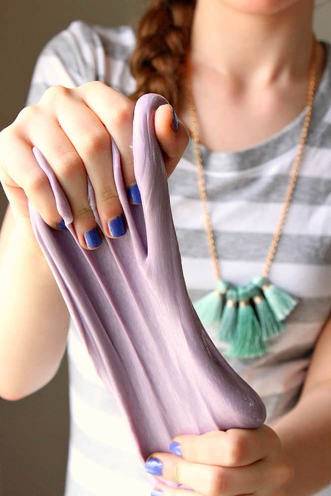 Close up on DIY 3-Ingredient slime stretched in hands. 