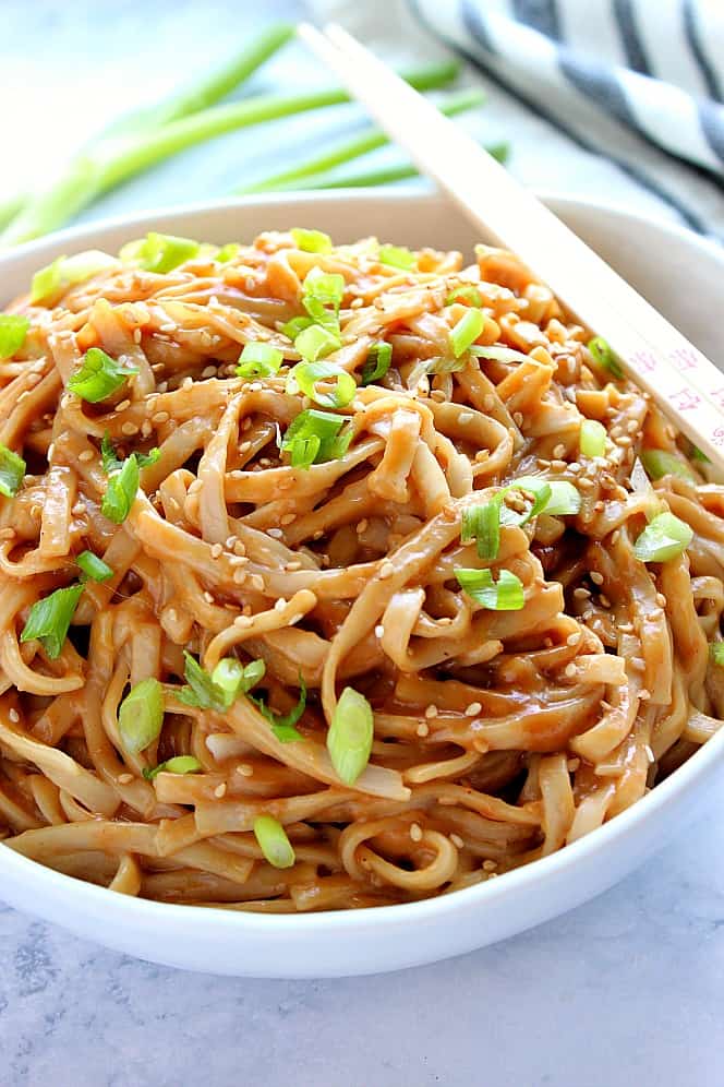 Side close up shot of peanut noodles in a white bowl. 