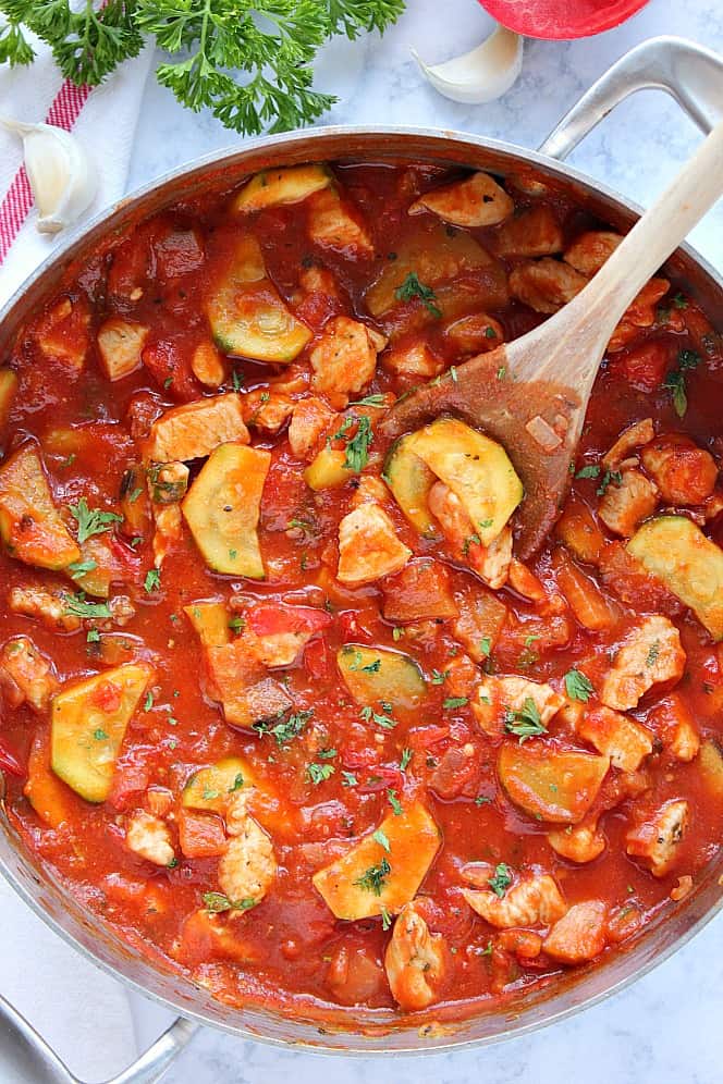 Overhead shot of chicken ratatouille in stainless steel pan. 