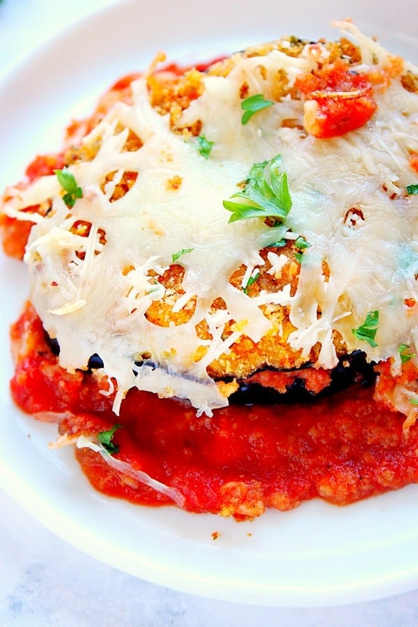 Cheesy Eggplant Parmesan on a white serving plate.