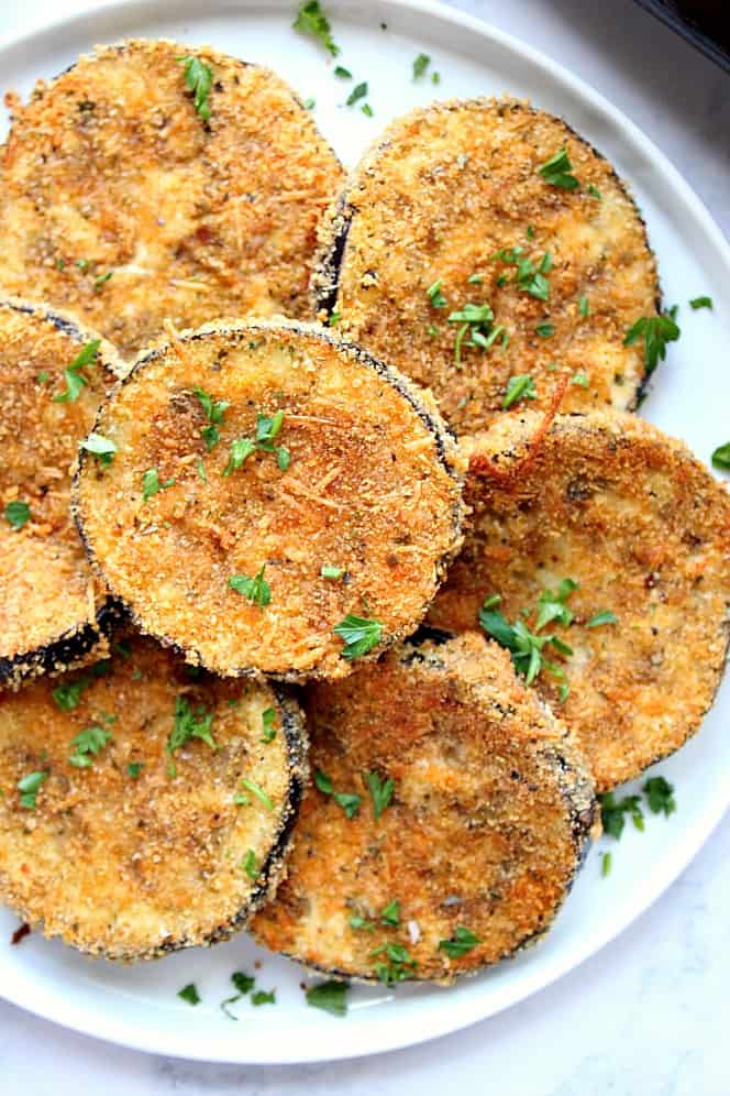 Baked Eggplant with golden breading, on white plate.