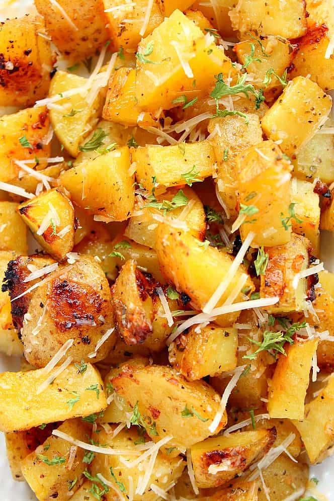 Close up shot of roasted potatoes with Parmesan cheese and parsley.