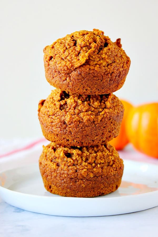 Healthy Pumpkin Muffins Recipe - soft, moist and delicious pumpkin muffins made with oat flour, no dairy or eggs! Each muffin has about 145 calories. Three Healthy Pumpkin Muffins stacked on each other.