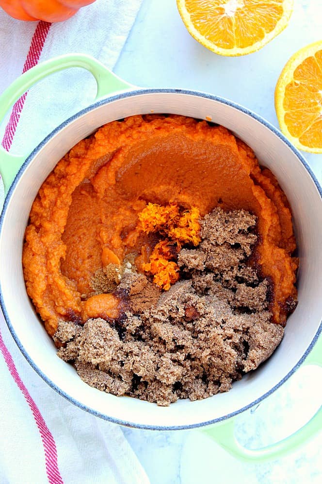 Overhead shot of cast iron saucepan with pumpkin puree, spices and brown sugar. 