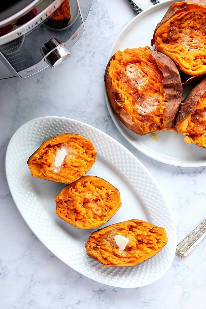 Overhead shot of sweet potatoes cooked in pressure cooker, served on white plates. 