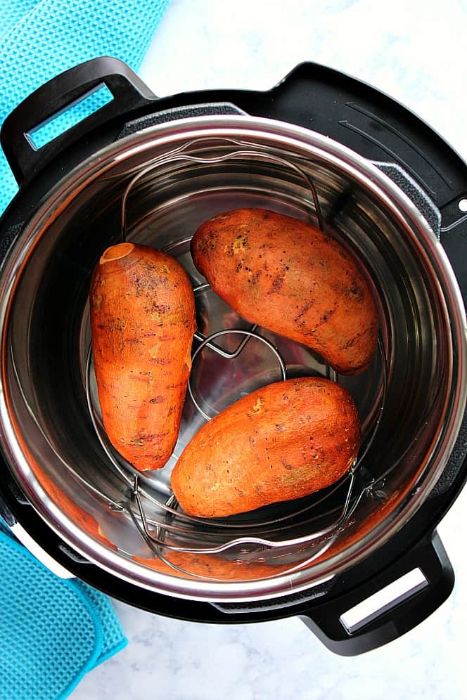 Overhead shot of Instant Pot with three sweet potatoes on trivet. 