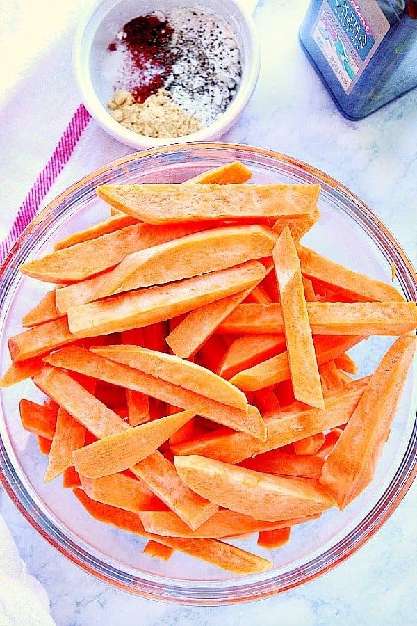 Overhead shot of cut sweet potatoes in glass bowl.