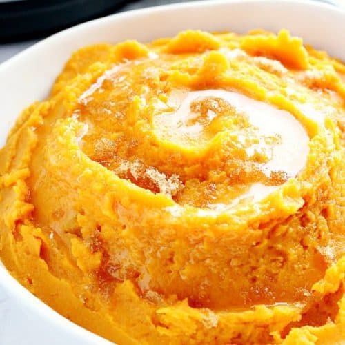 Instant Pot mashed sweet potatoes in white serving bowl.