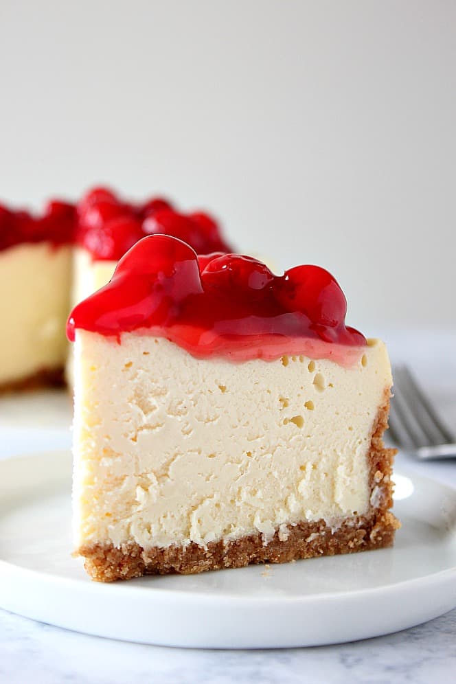 Slice of pressure cooker vanilla cheesecake on a small plate.