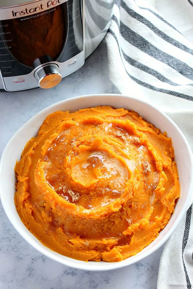 Overhead shot of mashed sweet potatoes in white bowl, next to Instant Pot.