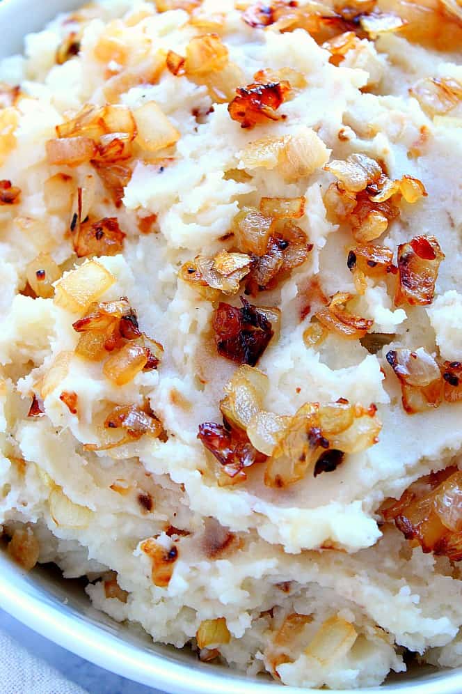 Close up shot of mashed potatoes with caramelized onions. 