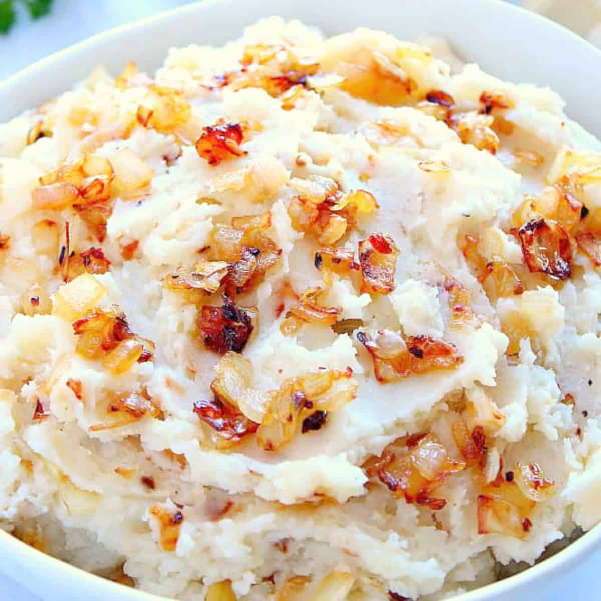 Mashed potatoes with caramelized onions in a bowl.