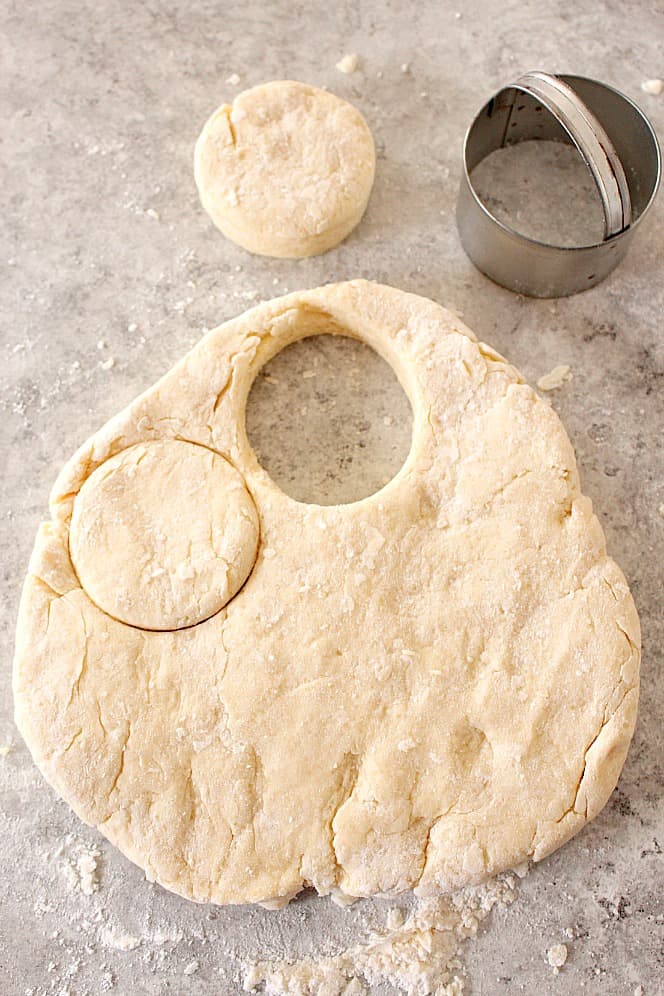 Buttermilk biscuit dough with rounds cut out.